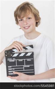 White background studio photograph of young happy boy smiling hand holding a filmmaker&rsquo;s clapperboard