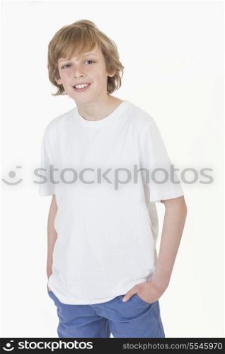 White background studio photograph of young happy boy smiling hands in pockets wearing blue denim jeans and white T-shirt