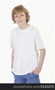 White background studio photograph of young happy boy smiling hands in pockets wearing blue denim jeans and white T-shirt