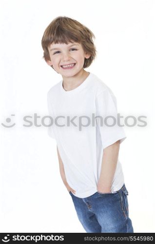 White background studio photograph of young happy boy smiling wearing blue denim jeans hands in pockets