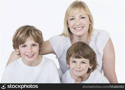 White background studio photograph of young happy family mother and two boy sons smiling