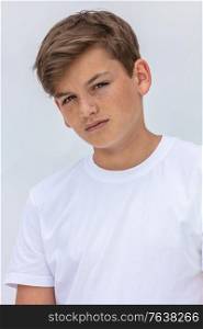 White background studio portrait of a boy teenager teen male child wearing a white t-shirt