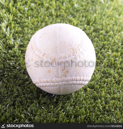White baseball over synthetic grass, square image