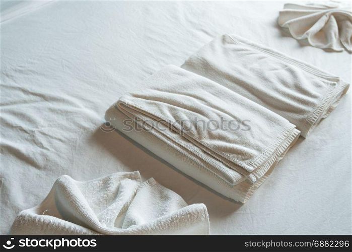 White bath towel on white bed in room hotel.