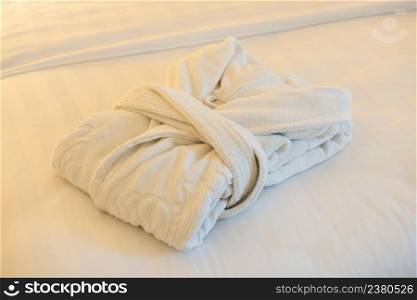 white bathrobe on the bed in the bedroom of the hotel room, close-up. bathrobe in the bathroom