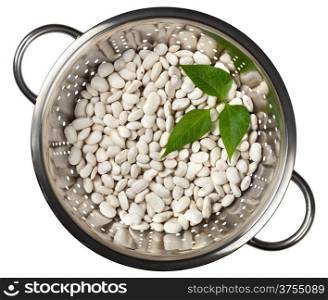 White beans with green leaves in a colander isolated on white background, top view