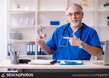 White bearded old doctor working in clinic 