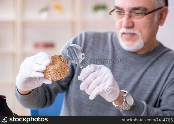 White bearded old jeweler at workshop 