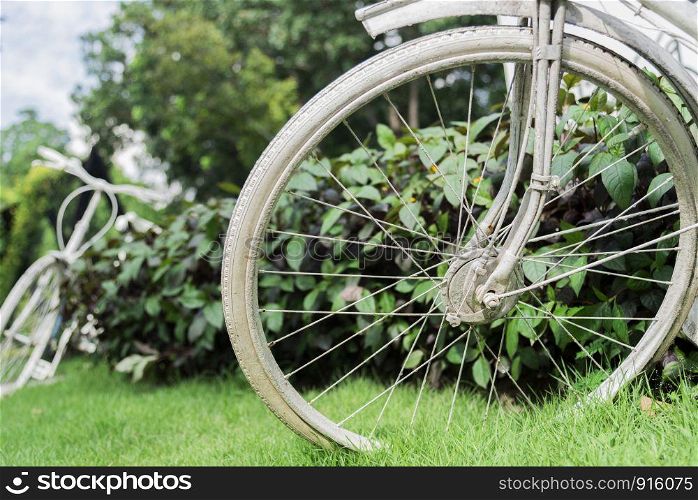 White bicycle in garden background. Vintage and nature concept. Close up and bike handle.