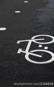 white bicycle road sign painted on the asphalt road (bicycle lane)