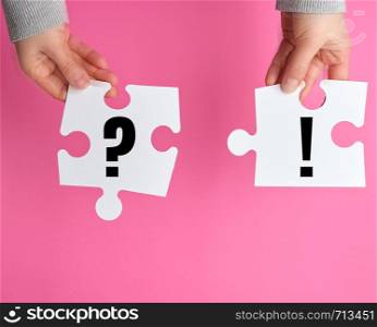 white big puzzle in female hand on pink background, business concept, top view