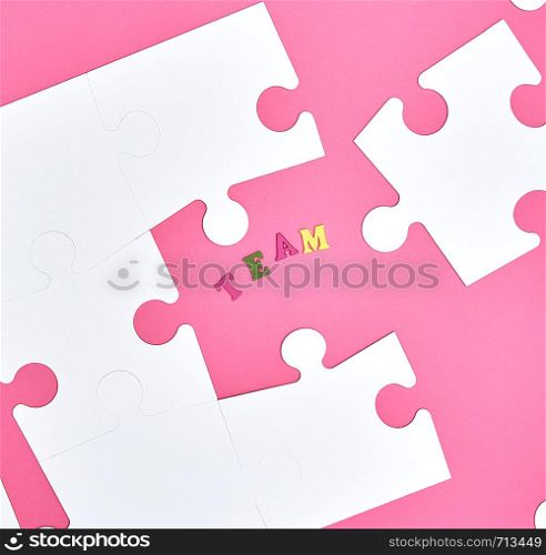 white big puzzles on a pink background, inscription team, the concept of recruitment in the company