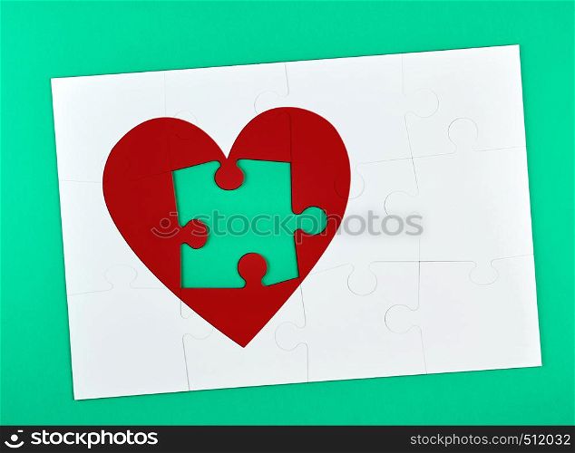 white big puzzles, one element from the red heart shape is missing, green background