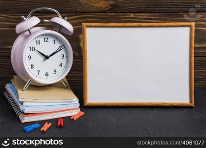 white blank board alarm clock clothes peg notebooks black desk