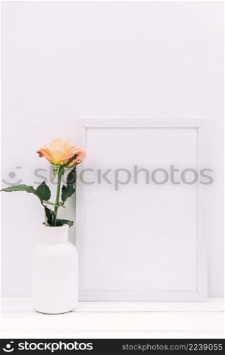 white blank frame fresh rose wooden table