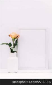white blank frame fresh rose wooden table