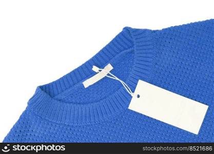 White blank rectangular clothing tag, label mockup template on blue knitted sweater isolated on white background . Price tag label with copy space for text. Shopping, sale, discount, black friday. White blank rectangular clothing tag on blue knitted sweater isolated on white background