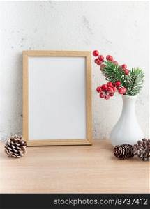 White blank wooden frame mockup with Christmas decorations  on the wooden table.  Frame for"es. Christmas postcard. 
