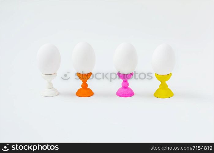 White boiled eggs on wooden molds on a white background. Preparing for the Easter holiday.. White boiled eggs on wooden molds on a white background.