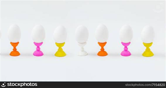 White boiled eggs on wooden molds on a white background. Preparing for the Easter holiday.. White boiled eggs on wooden molds on a white background.