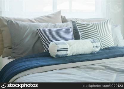 White bolster and pillows on bed in modern classic bedroom interior