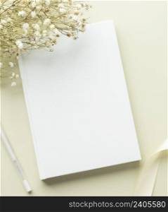White book blank cover mockup on a beige background with dry flower, flat lay, mockup