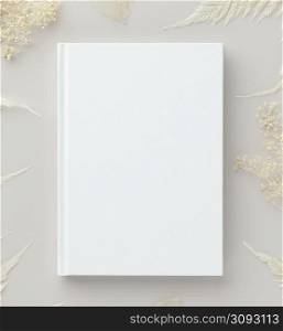 White book mockup with dry flowers on a beige background, flat lay, mockup