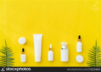 White bottle cream, mockup of beauty product brand. Top view on the yellow background.