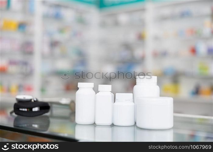 white bottle medicine on counter and shelf medicine in pharmacy background