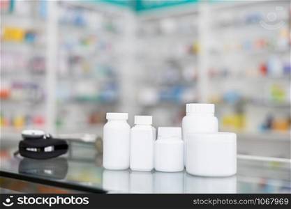 white bottle medicine on counter and shelf medicine in pharmacy background