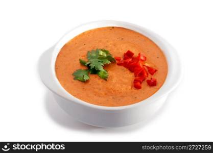 White bowl of gaspacho soup on white background