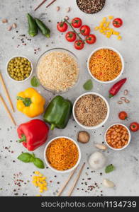 White bowl plates with boiled long grain basmati rice with vegetables and mushrooms on light background with sticks and paprika pepper with corn,garlic and basil with beans and peas.