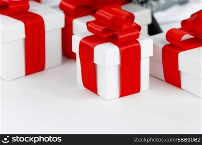 White boxes with gifts decorated with red ribbons on white background