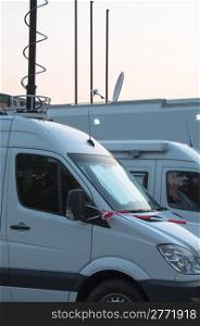 White broadcast trucks recording and broadcasting a live event