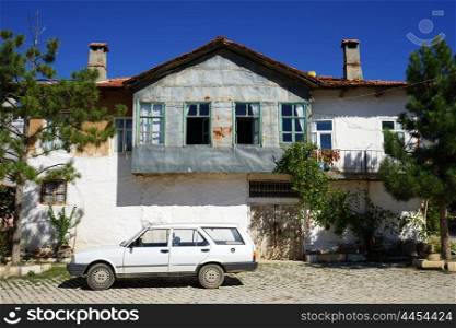White building and car on the street in turkish village, Turkey