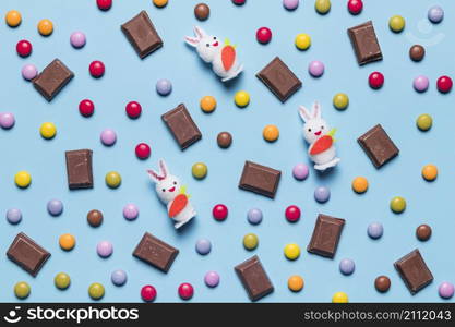 white bunnies gem candies chocolate pieces blue backdrop