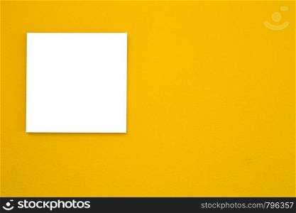 White canvas frame on yellow wall texture background. space for text, modern retro design close-up. White canvas frame on yellow wall texture background. space for text, modern retro design