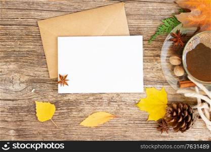 white card fall invitation, leaves and coffee on wooden autumn background. Fall leaves autumn background