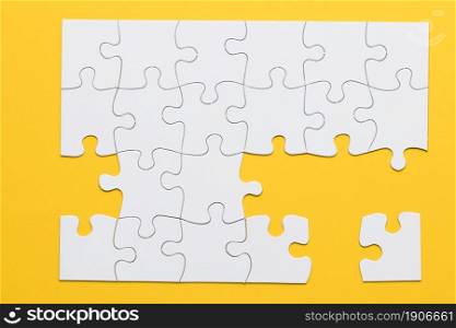 white cardboard jigsaw puzzles yellow background. High resolution photo. white cardboard jigsaw puzzles yellow background. High quality photo