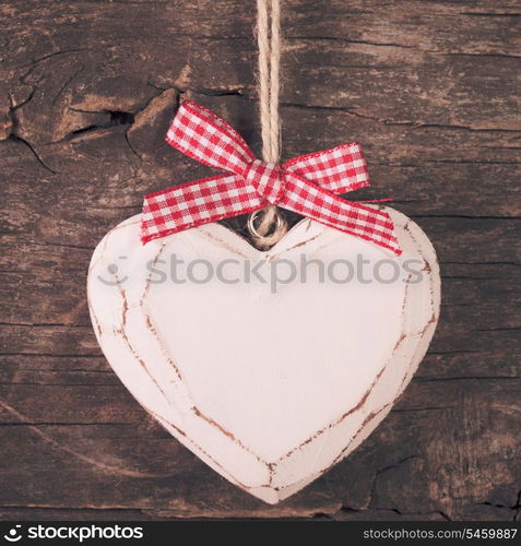 White carved heart over old wooden background, valentine decor