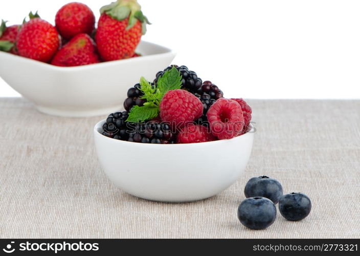 White ceramic bowl of sweet berries fruits.