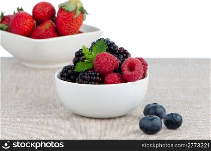 White ceramic bowl of sweet berries fruits.