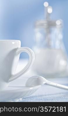 white ceramic coffee cup and spoon and sugar bowl