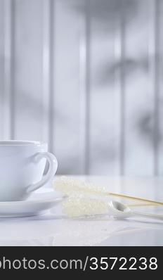 white ceramic cup and sugar stick