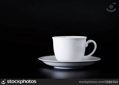 White ceramic mug of coffee on a black background.
