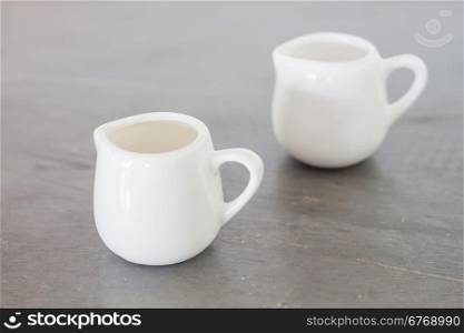 White ceramic pitcher on grey background, stock photo