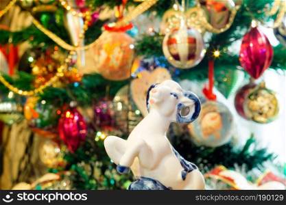 White ceramic ram on background with Christmas decorations.