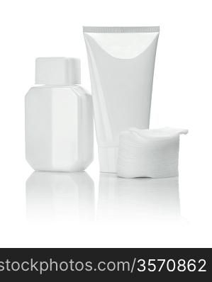 white ceramical bottle and tube with cotton pads
