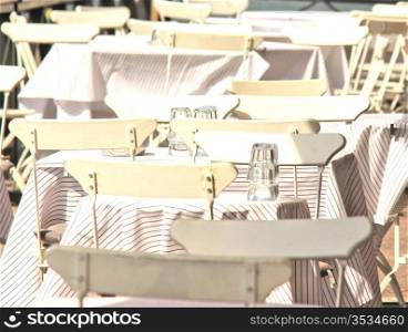 White chairs and tables, outdoors at a restaurant