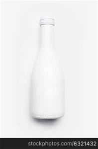 White champagne bottle on white desk background, top view. Minimal party layout or holidays mock up